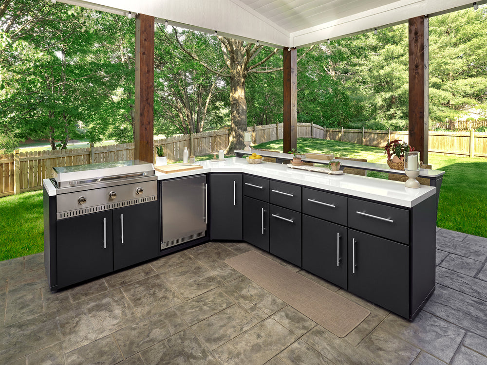 Emory corner outdoor kitchen with a flat top griddle, stainless steel fridge, and white countertops.