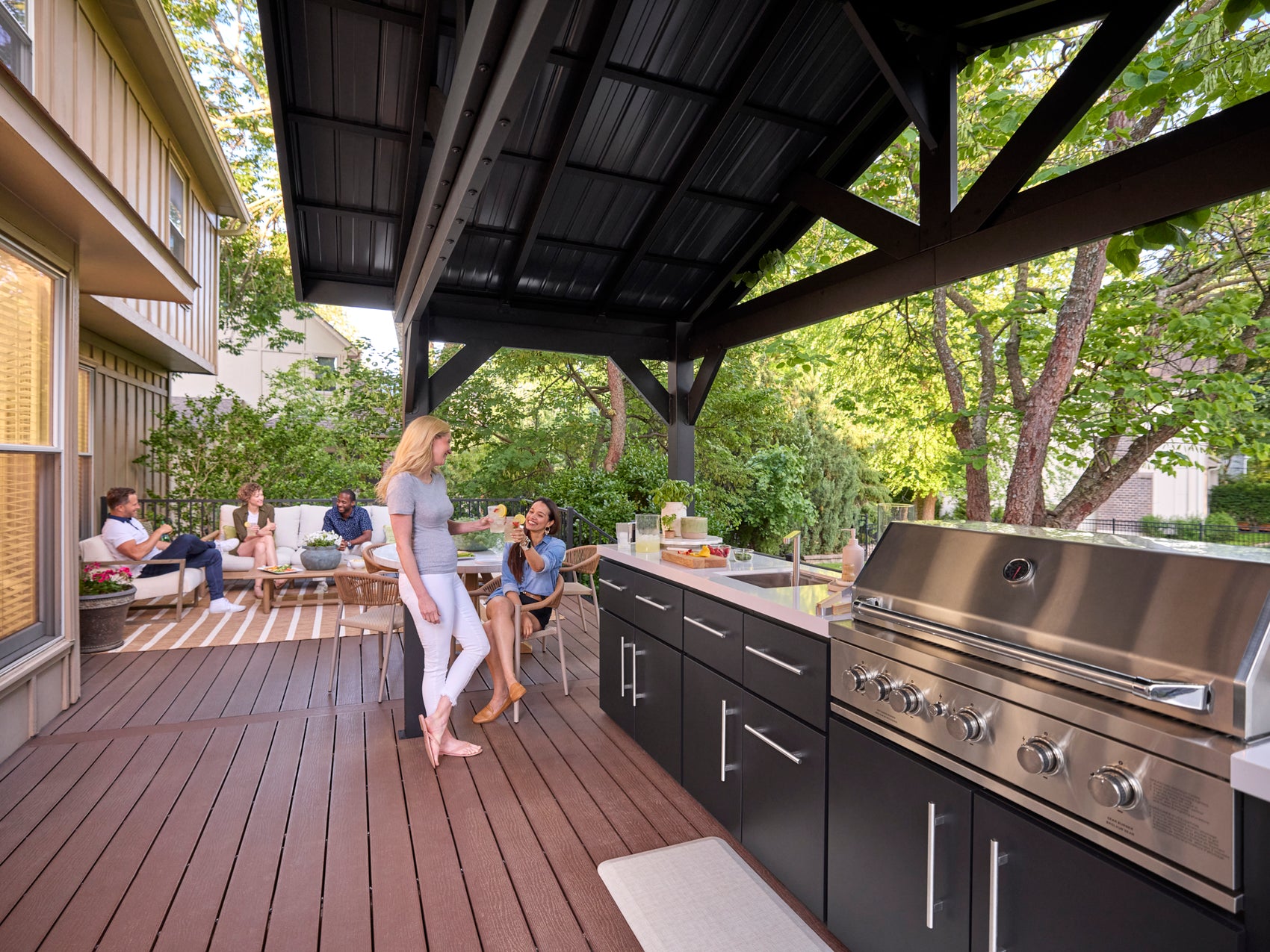 Powder coated galvanized steel roof built into Lancaster outdoor kitchen with dark cabinetry and 5-burner grill.