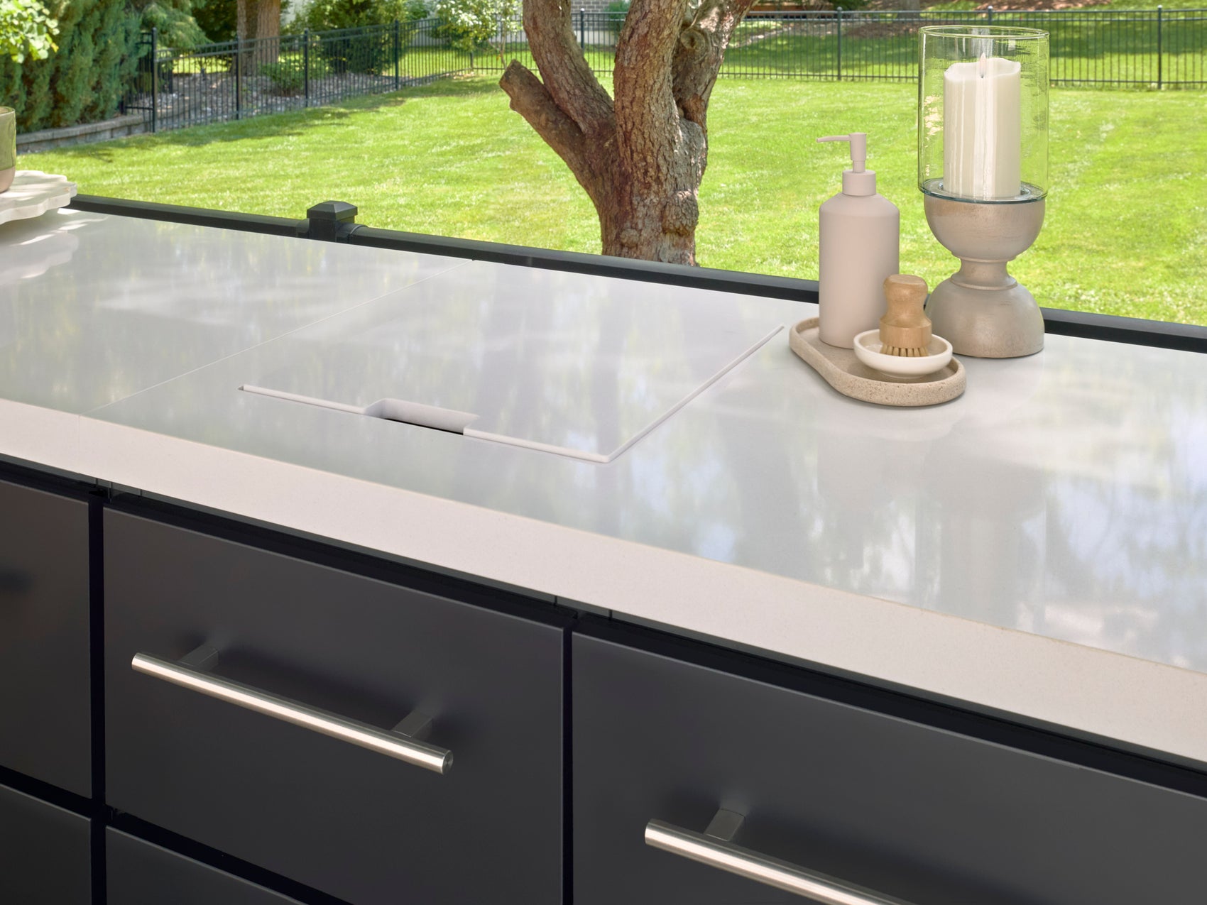 Lancaster modern outdoor kitchen with integrated sink in white countertop, black cabinetry.
