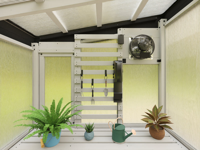 Interior view of a 9x6 white cedar frame greenhouse with slat wall and exhaust fan.

