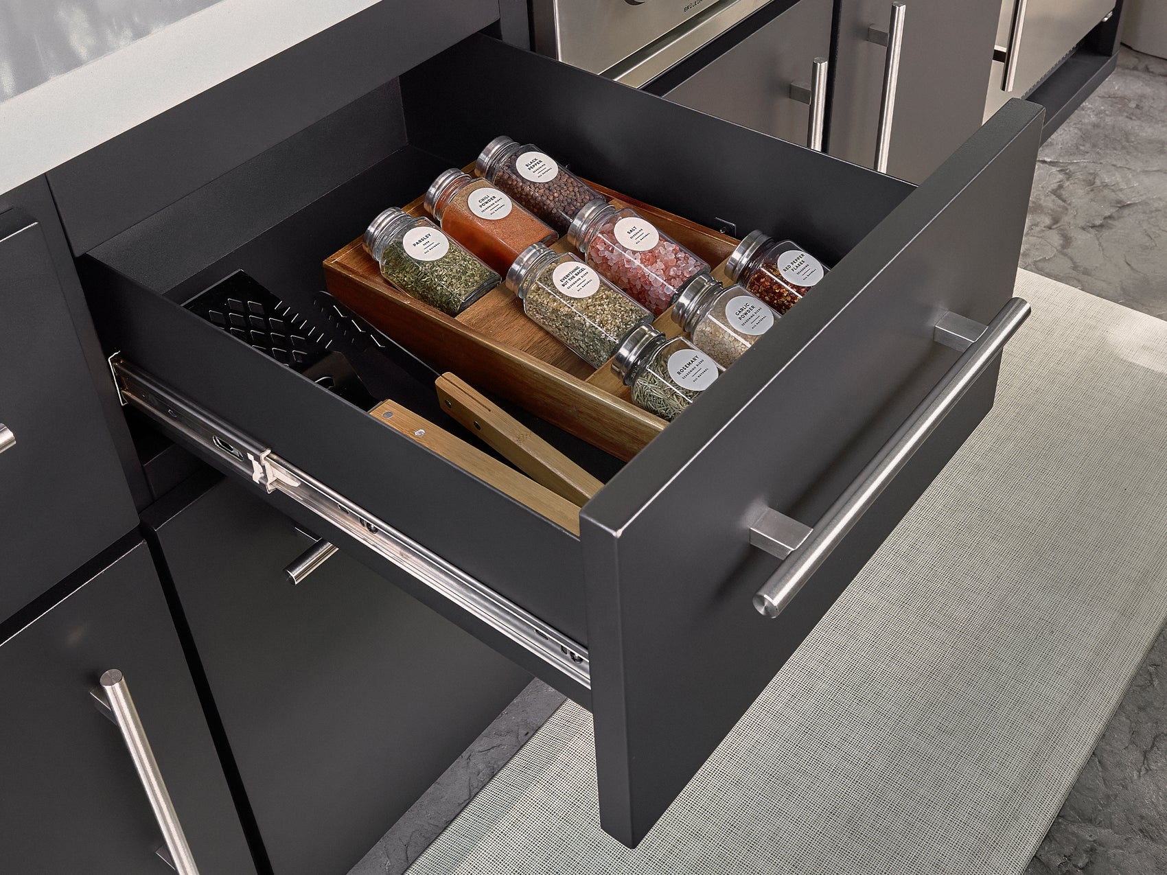 Powder coated galvanized steel drawer with soft close design, open for BBQ tool storage in Edgemont Bay outdoor kitchen.