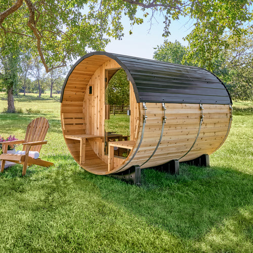 Backyard Discovery Paxton 4-6 person barrel sauna with front porch and cedar bench seating in sunny setting