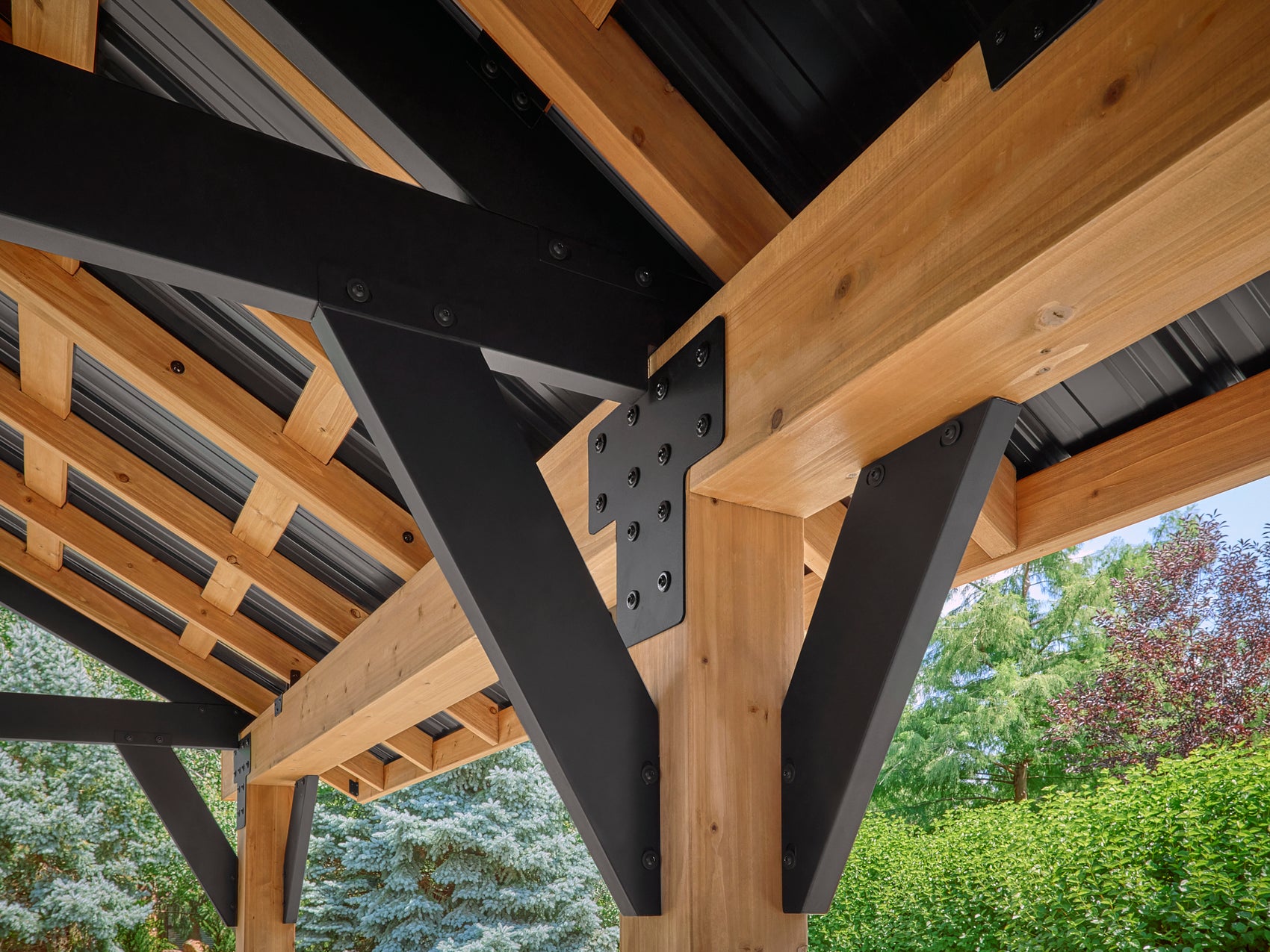 Steel bracket connecting wood beams with visible Lodge gazebo hardware and metal fasteners on outdoor structure.