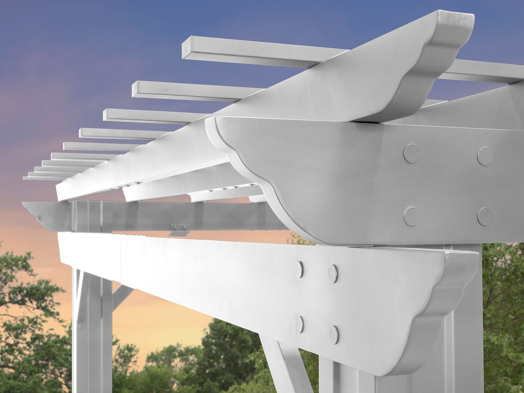 White steel Stratford backyard pergola with trellis roof and curved support beams against twilight sky and greenery.