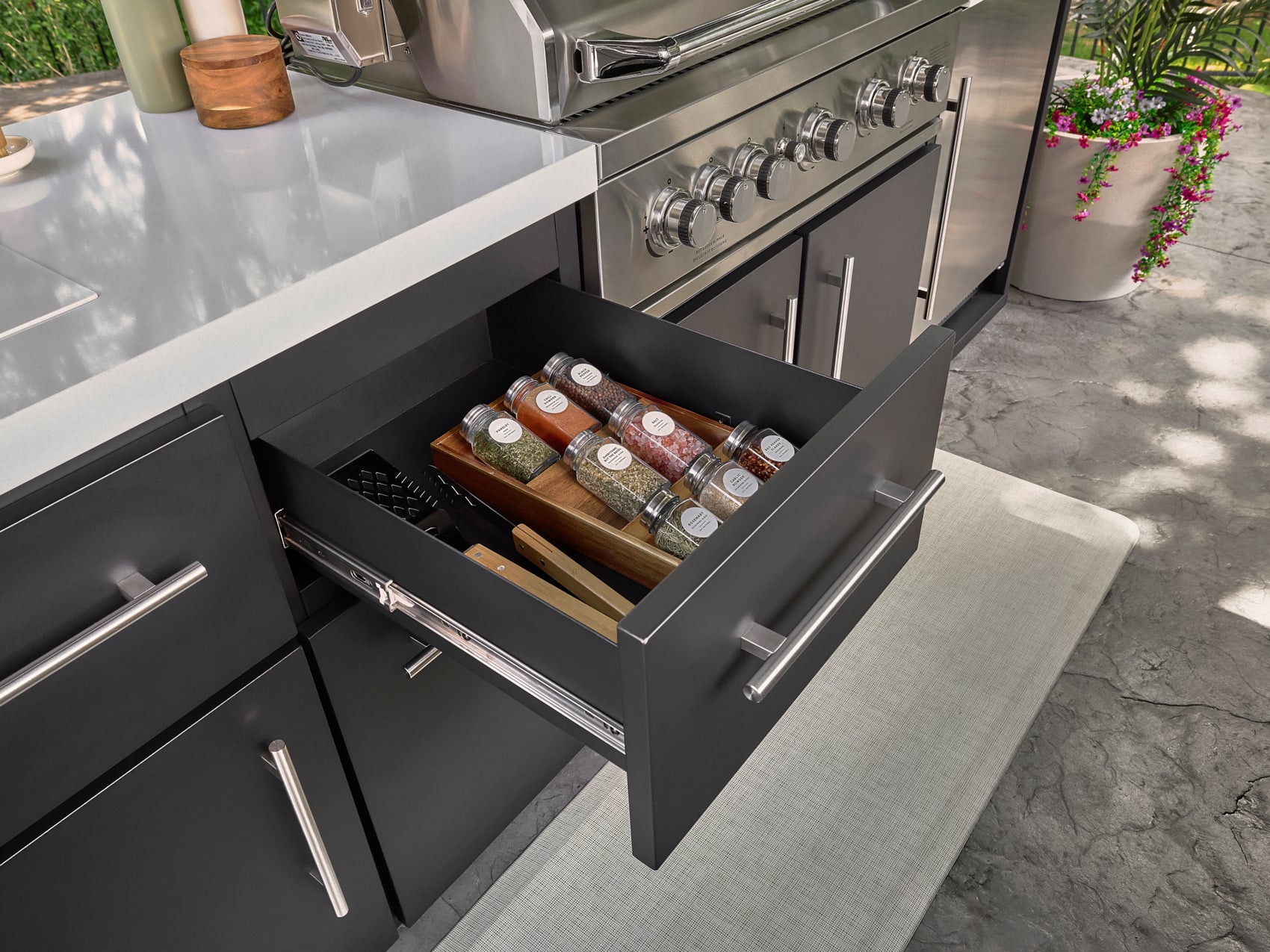 Soft-close outdoor storage drawer open with spice storage in Range Outdoor Living Lancaster kitchen.