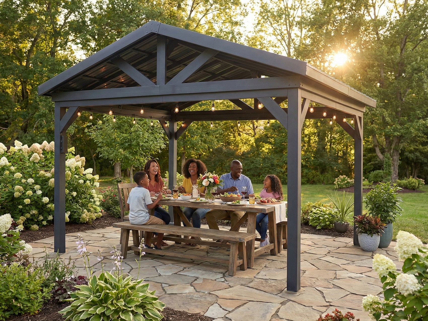 Steel Lancaster hardtop gazebo sheltering family dining on patio surrounded by hydrangeas and garden landscape.