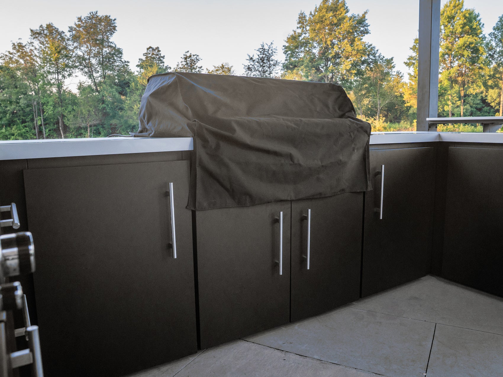 Range Outdoor Living stainless steel grill with weatherproof cover, built into Edgemont Bay outdoor kitchen.