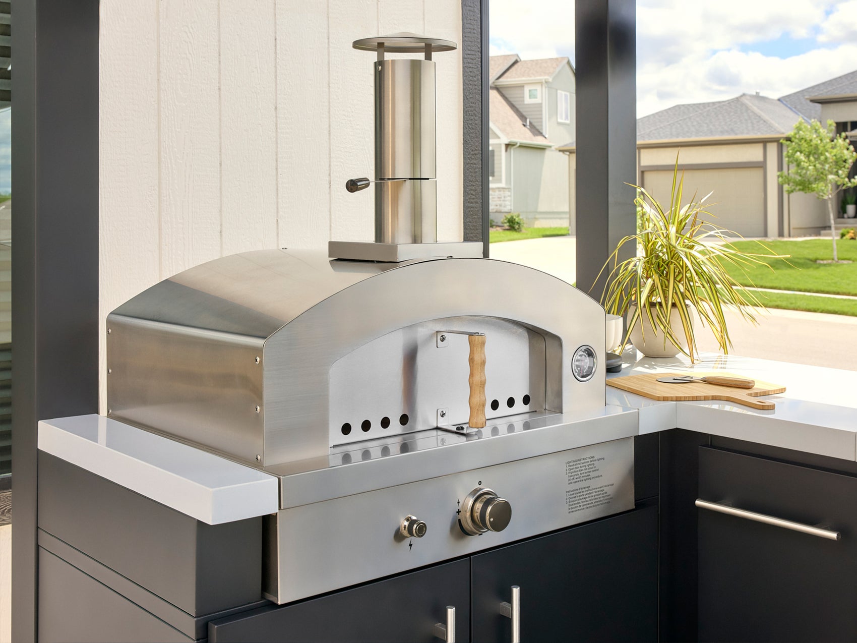 Range Outdoor Living stainless steel artisan pizza oven built into Edgemont Bay outdoor kitchen.