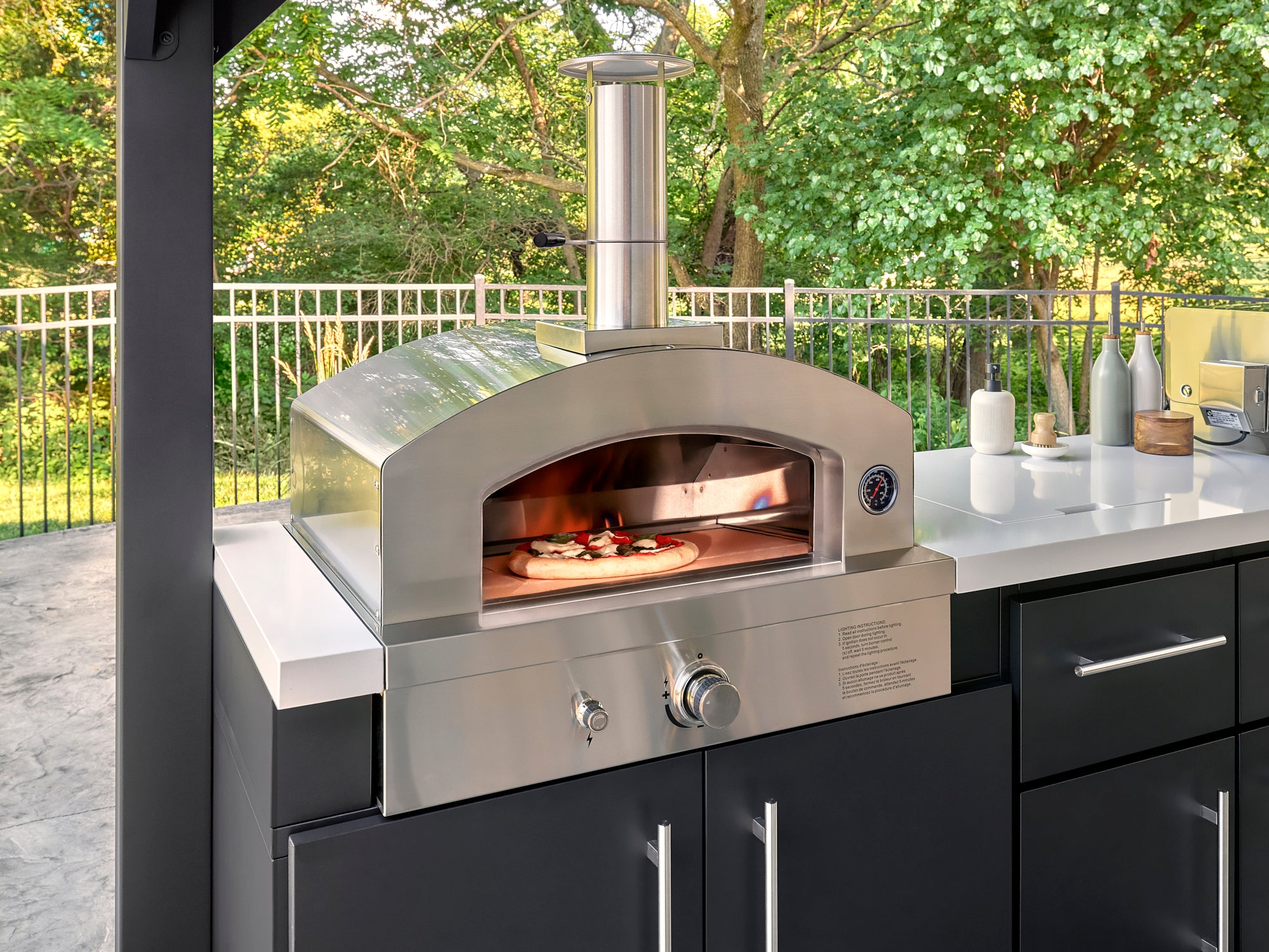Range Outdoor Living gas-powered patio pizza oven with built-in temperature gauge and chimney.