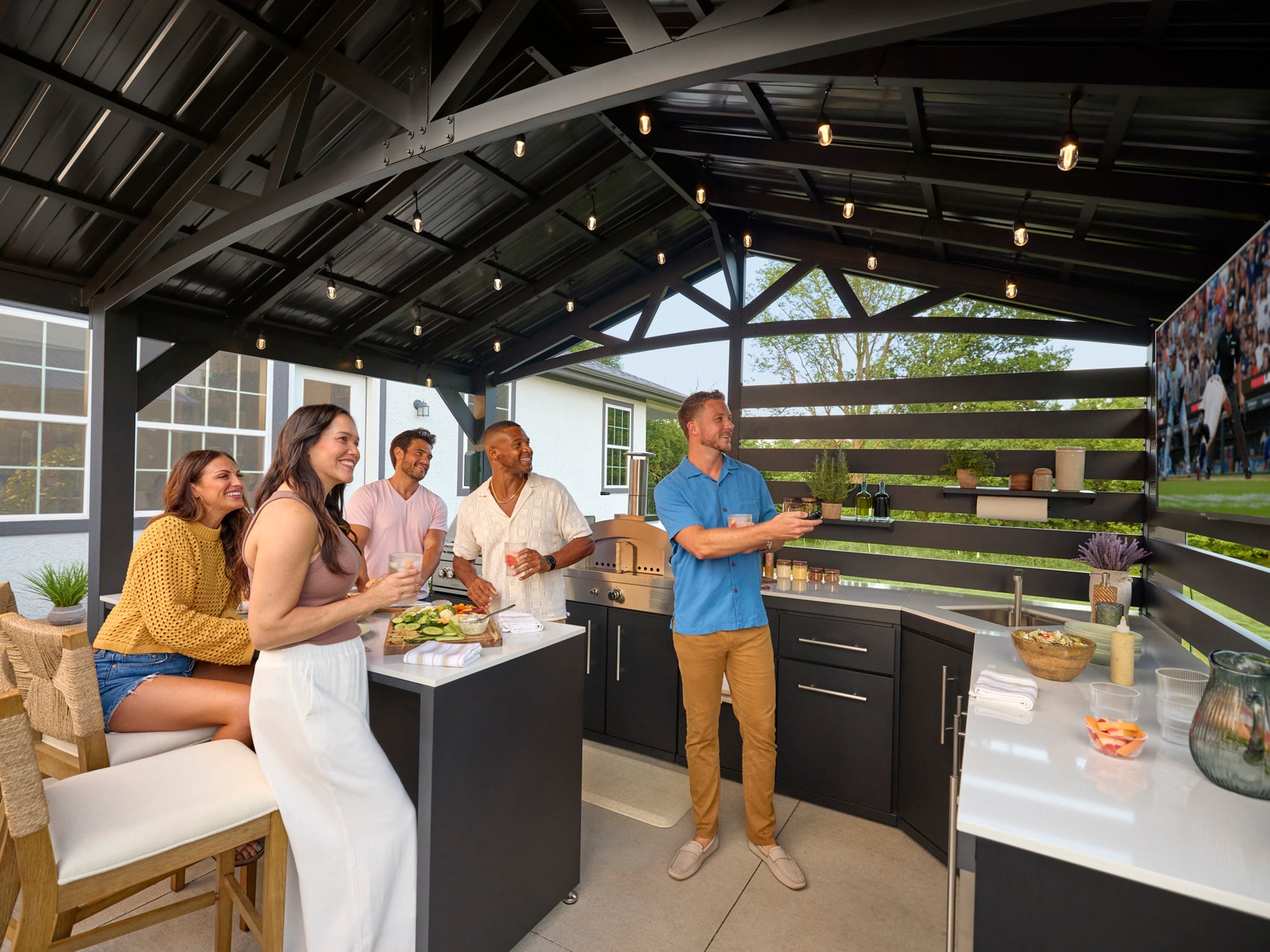 Modern steel pergola with trellis roof sheltering Langston outdoor kitchen where friends gather for backyard entertaining.