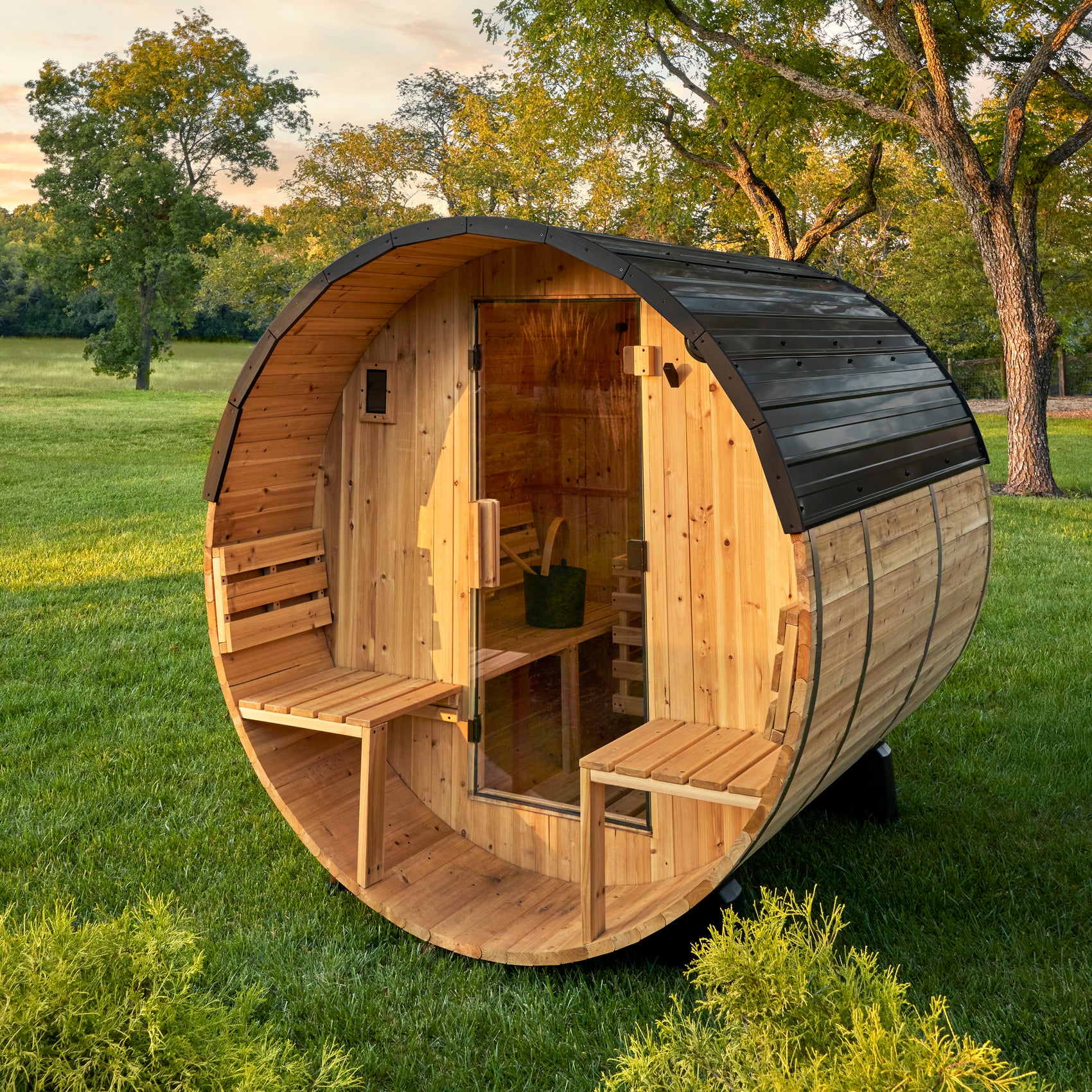 Backyard Discovery Paxton 2-4 person cedar barrel sauna with front porch and benches in sunny backyard
