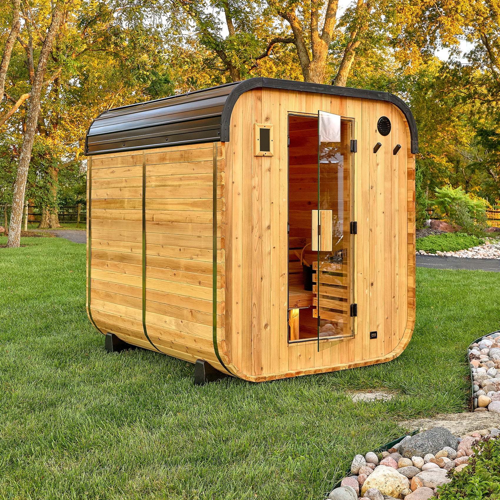 Backyard Discovery Lennon 4-6 person outdoor cube cedar sauna with glass door and steel roof in backyard