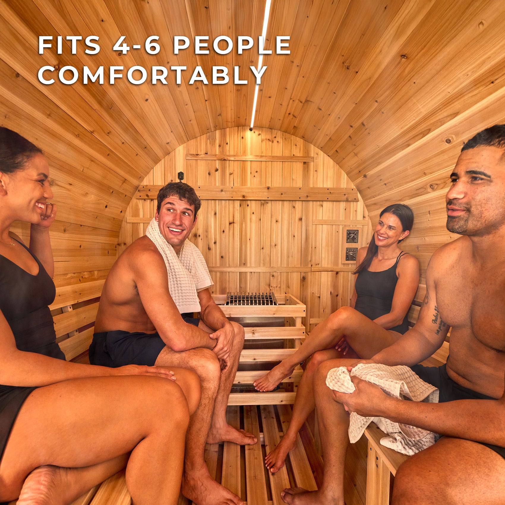 Four people socializing on cedar benches inside a Paxton outdoor barrel sauna enjoying sauna benefits