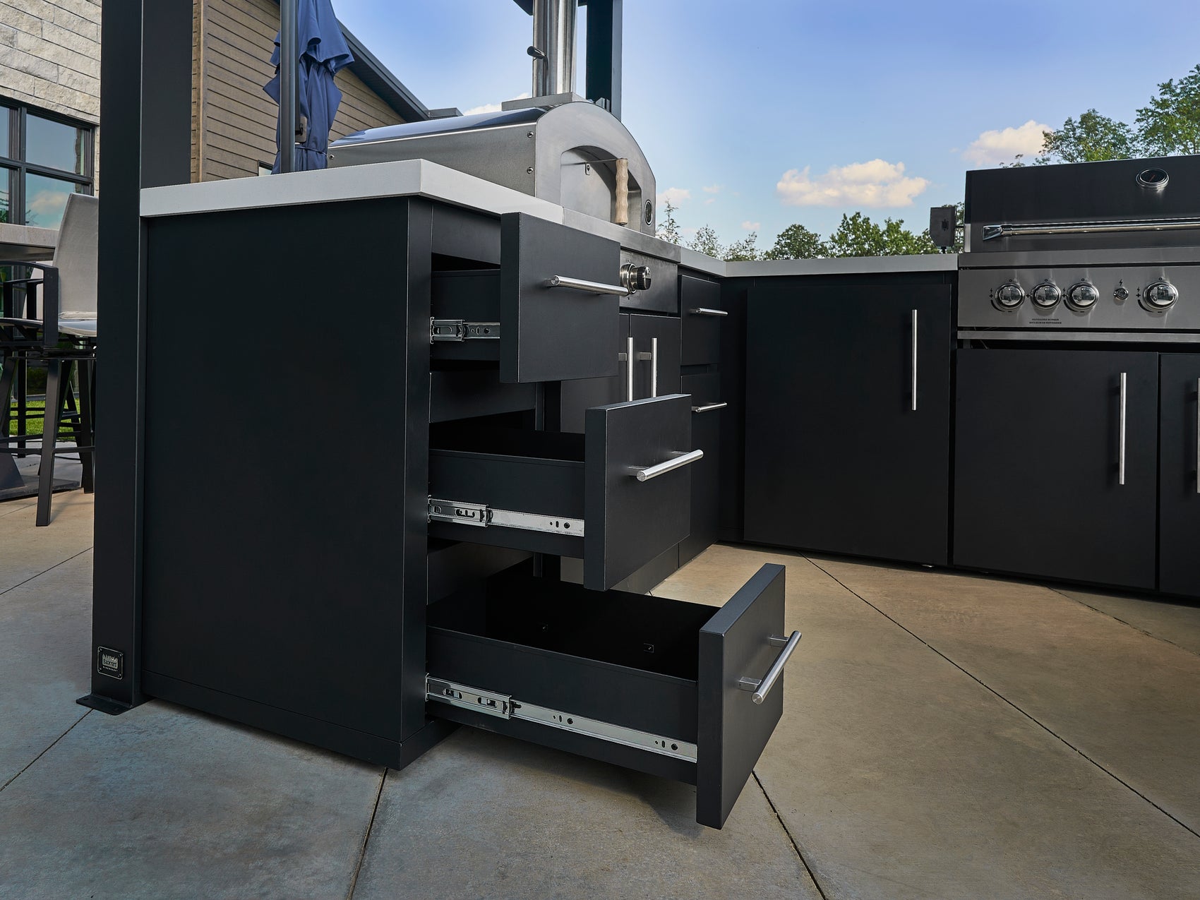 Three soft-close powder coated galvanized steel drawers with solid fronts built into Edgemont Bay outdoor kitchen island.