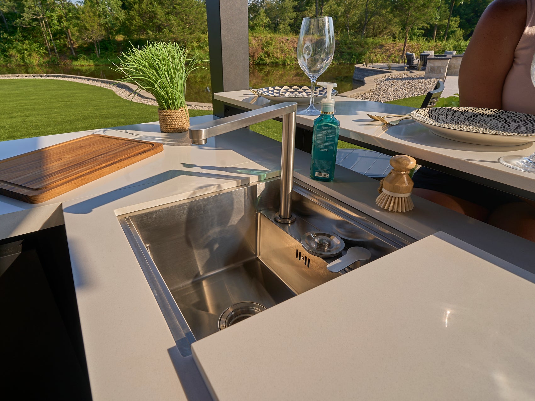 Stainless steel stowaway outdoor sink with engineered stone cover on Edgemont Bay kitchen counter.