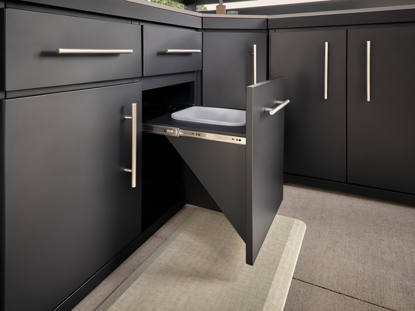 Modern Langston charcoal kitchen with pull-out trash compartment on drawer slides and sleek brushed nickel cabinet hardware.