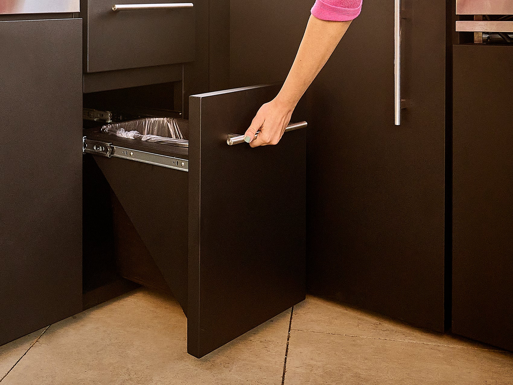 Pull out trash can in galvanized steel, powder coated design built into Edgemont Bay outdoor kitchen.