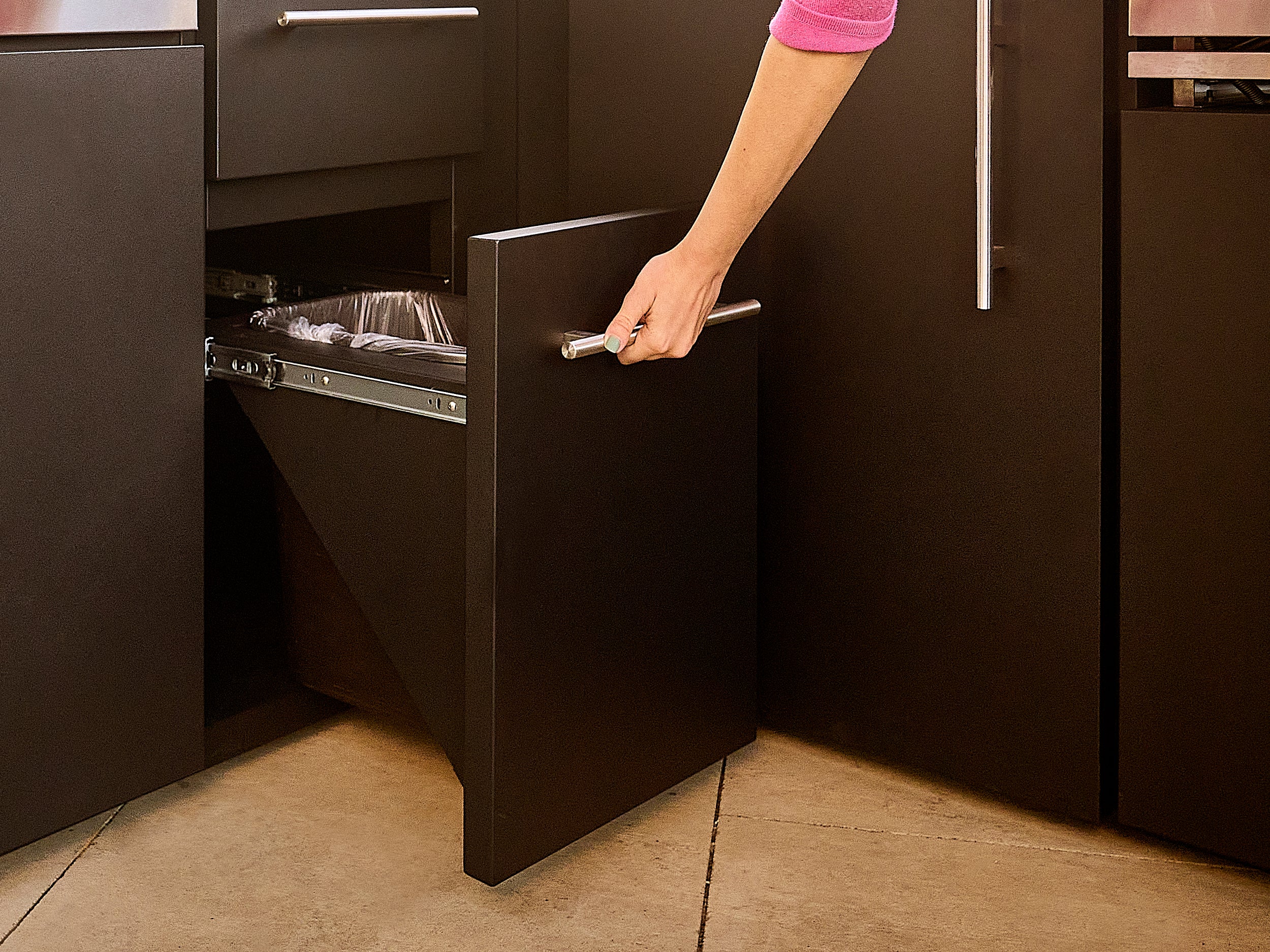 Pull out trash can in galvanized steel, powder coated design built into Edgemont Bay outdoor kitchen.