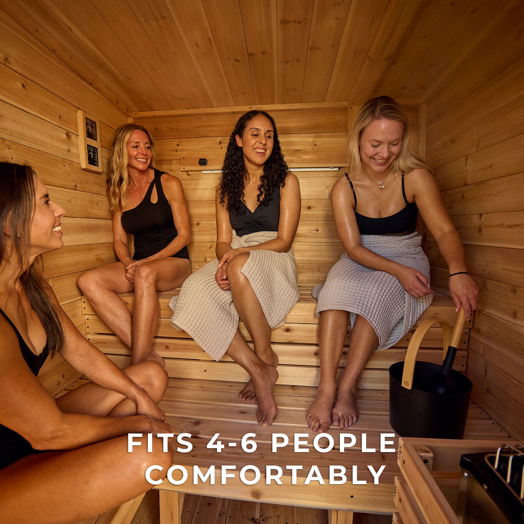 Four people socializing inside spacious Henley outdoor cabin cedar traditional sauna enjoying benefits