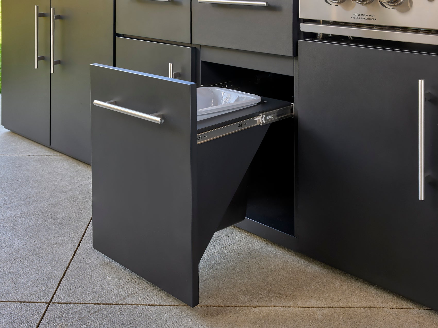 Range Outdoor Living Emory modern kitchen with dark gray cabinetry, pull-out trash drawer with metal slides.